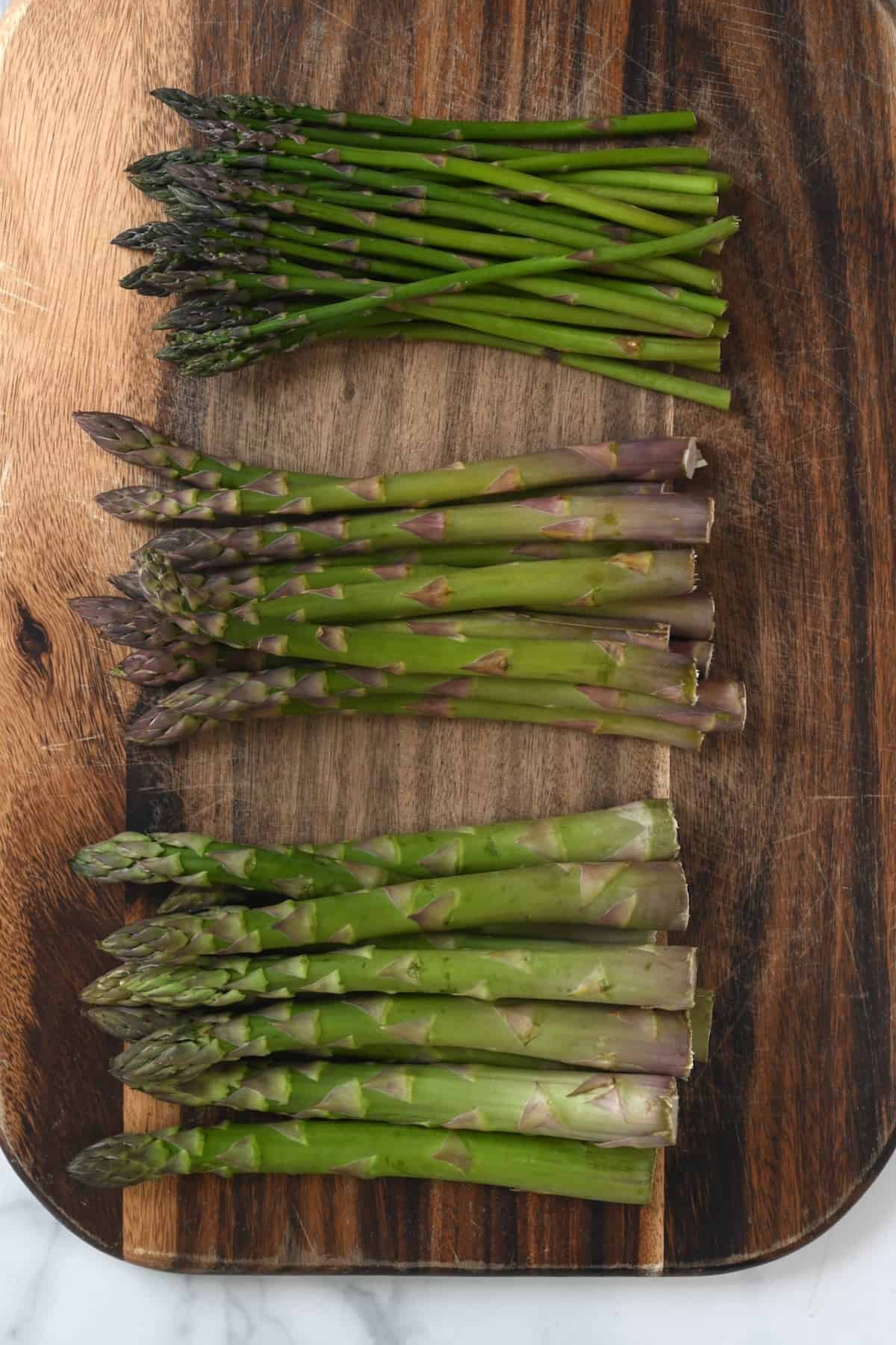Three bunches of asparagus with different thickness