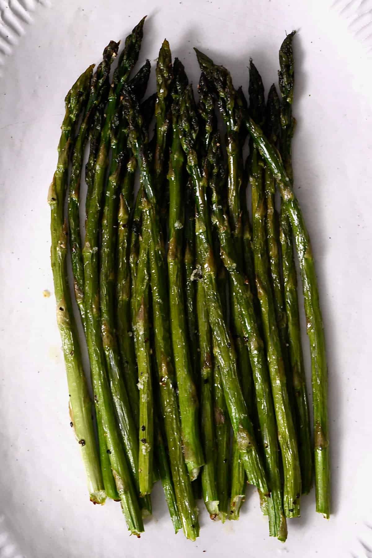 Oven roasted asparagus on a white plate