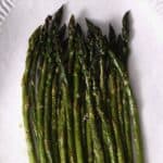 Oven roasted asparagus on a white plate