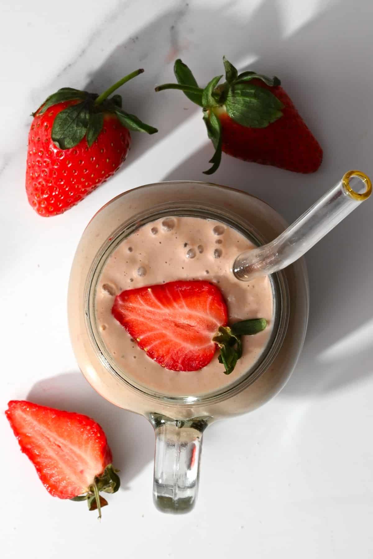 Smoothie topped with a strawberry slice in a jar