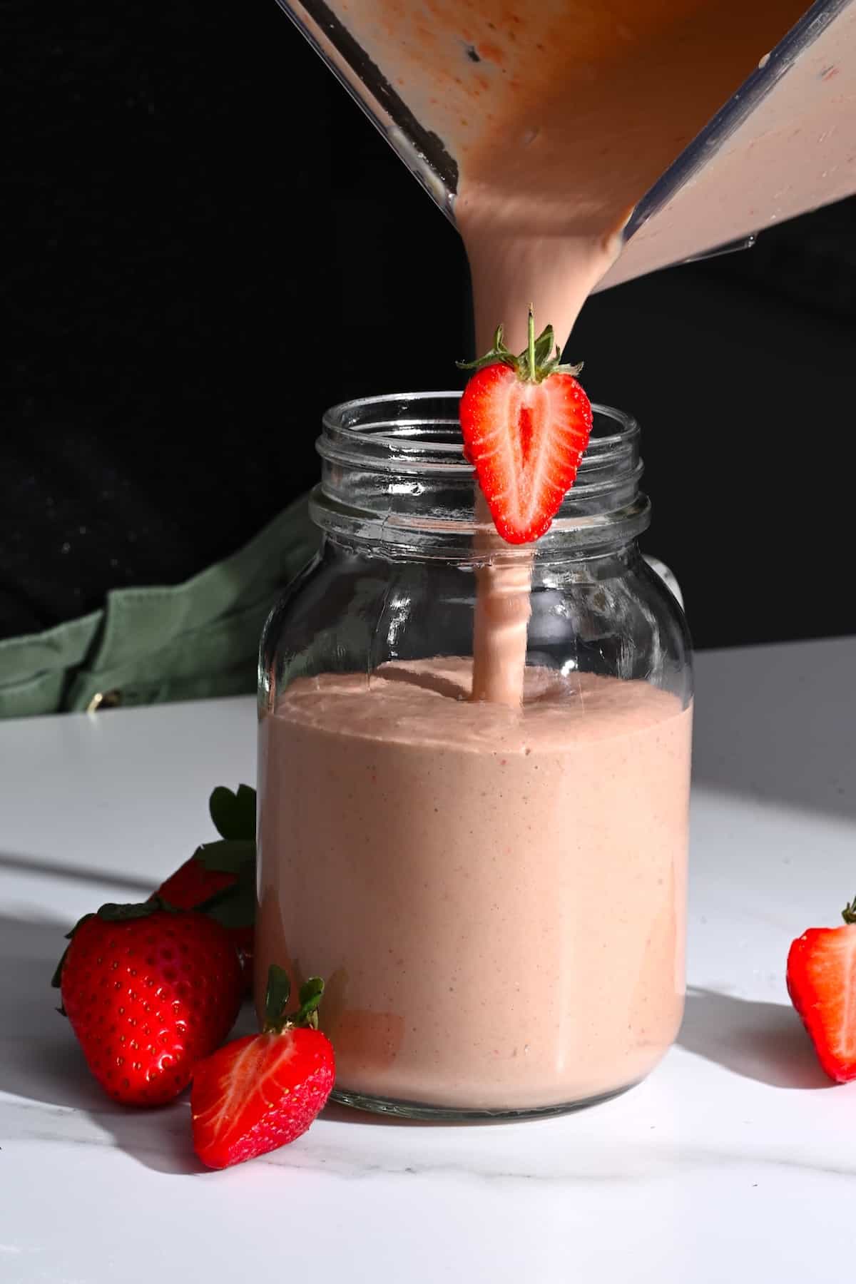 Pouring breakfast smoothie in a jar