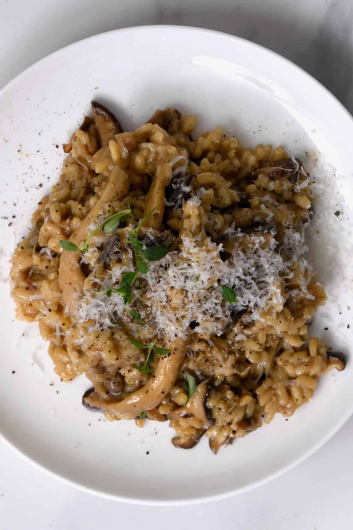 A serving of mushroom risotto topped with thyme