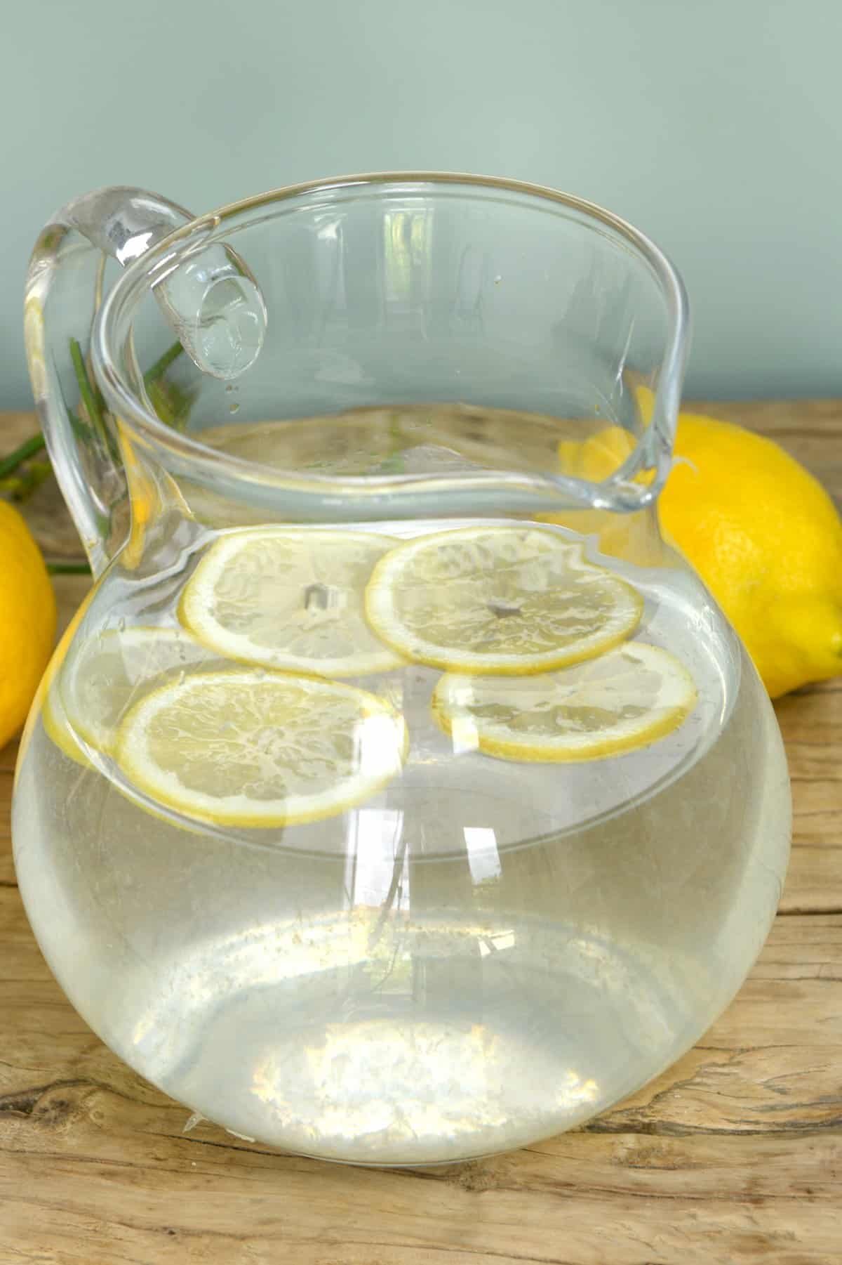 A pitcher with lemon water with few slices of lemon