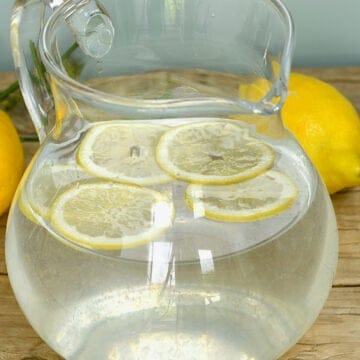 A pitcher with lemon water with few slices of lemon