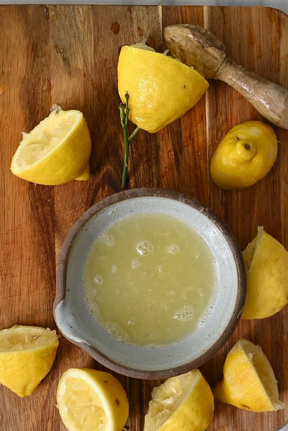Juiced lemons and a bowl with lemon juice