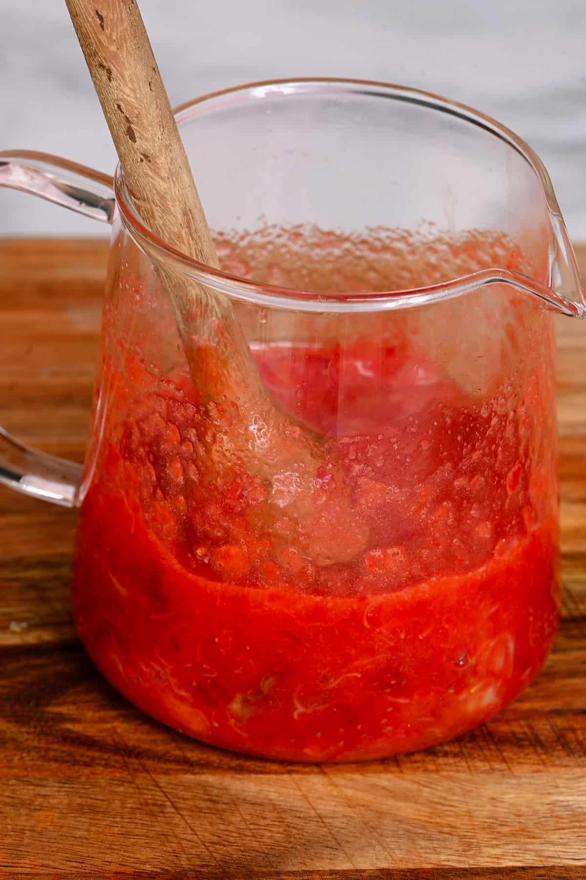 Strawberries muddled in a small glass container