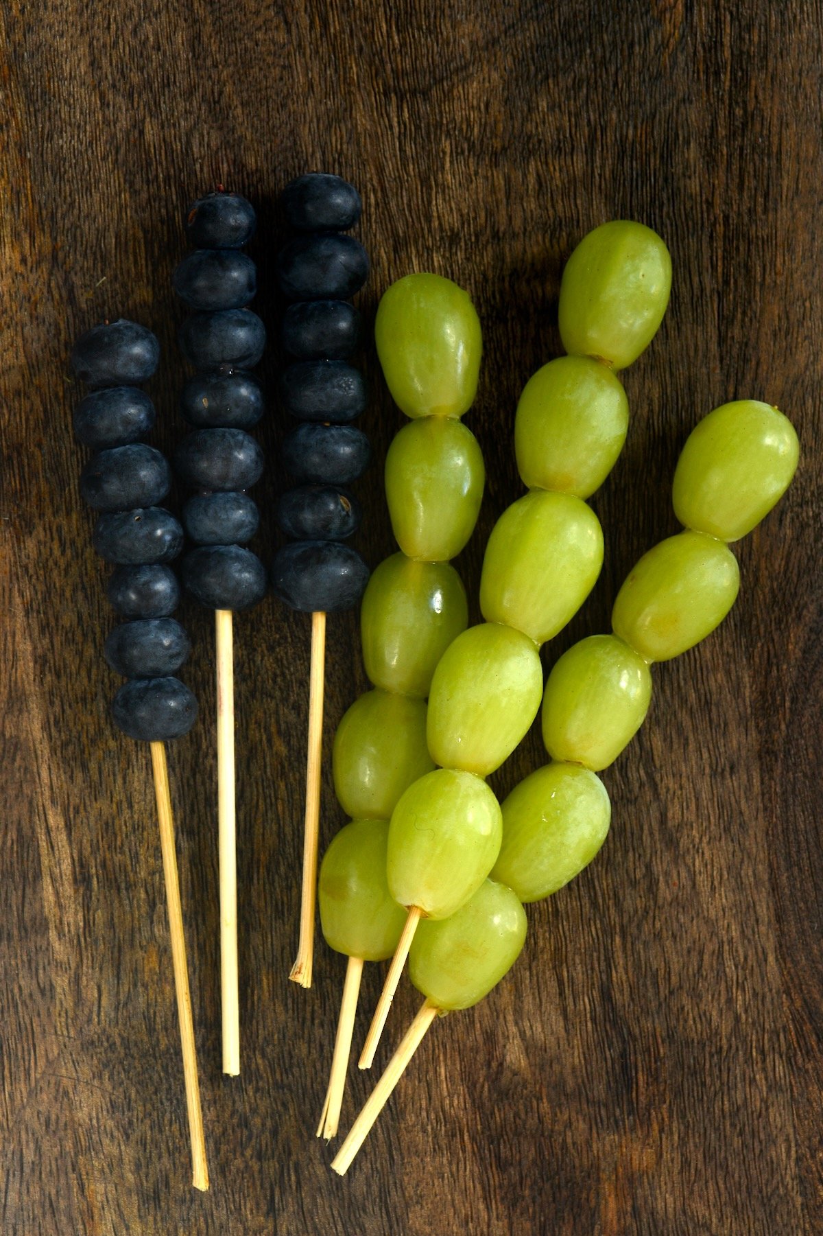 Blueberries and grapes arranged on wooden sticks