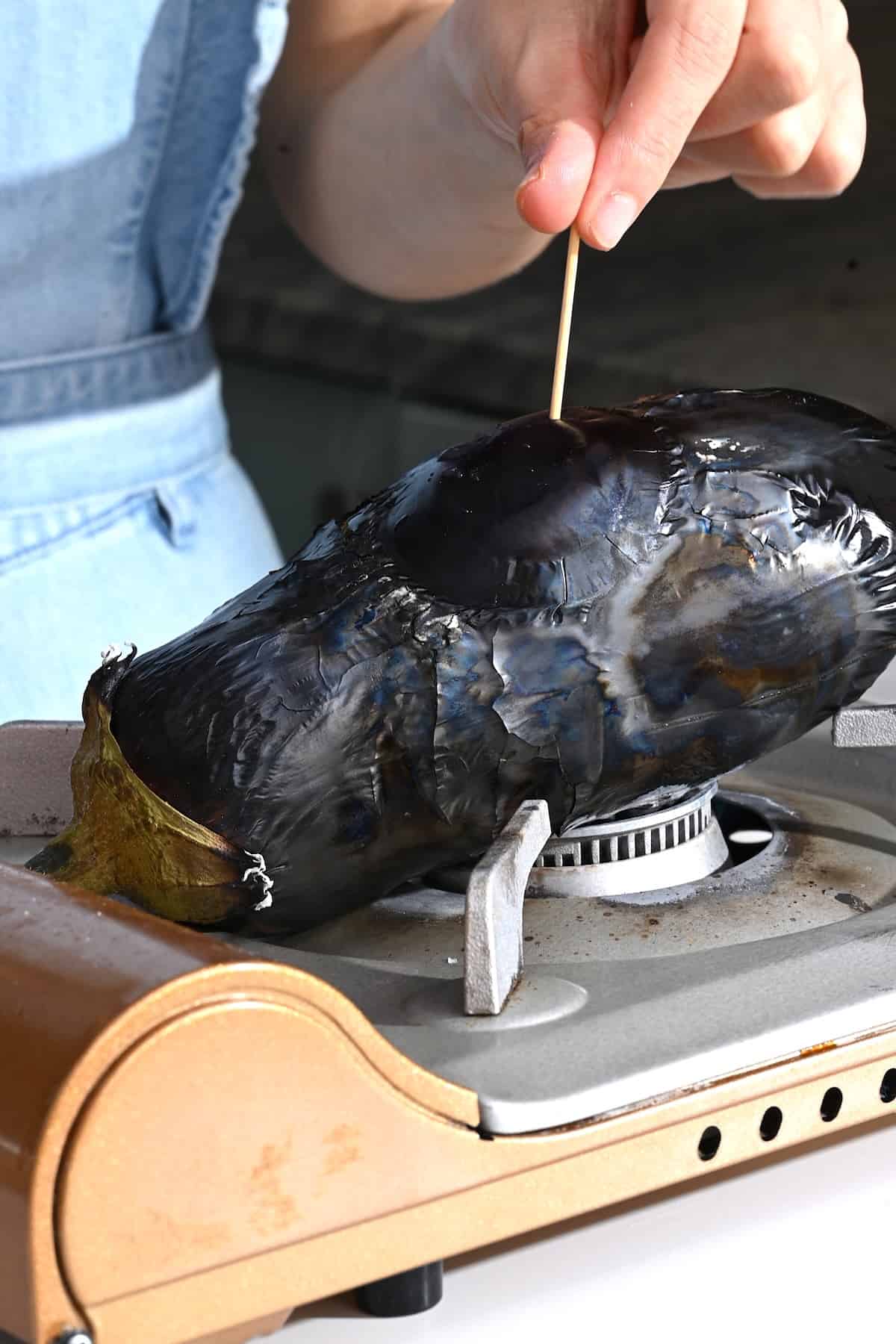 Charring an eggplant over open flame
