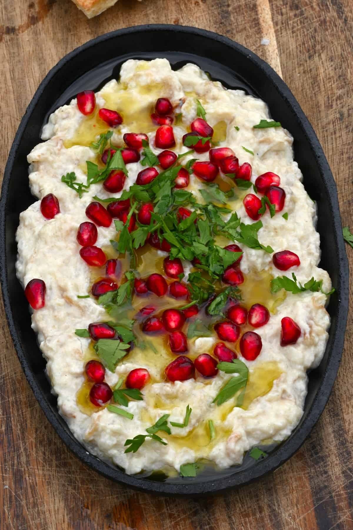 Homemade baba ghanoush topped with pomegranate seeds and parsley