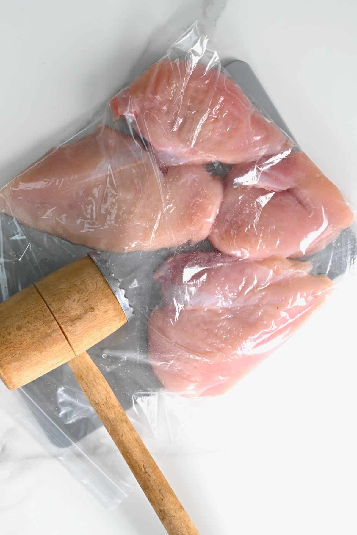 Using a mallet to tenderize chicken meat