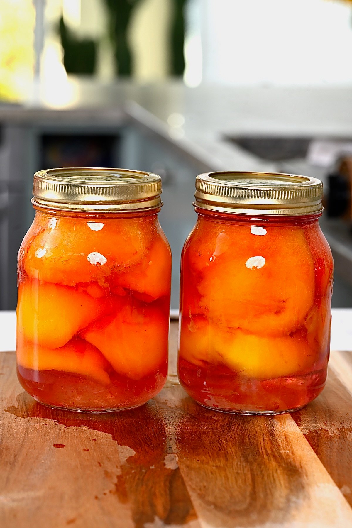 Two jars with canned peaches in light syrup