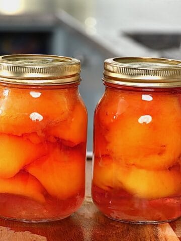 Two jars with canned peaches in light syrup
