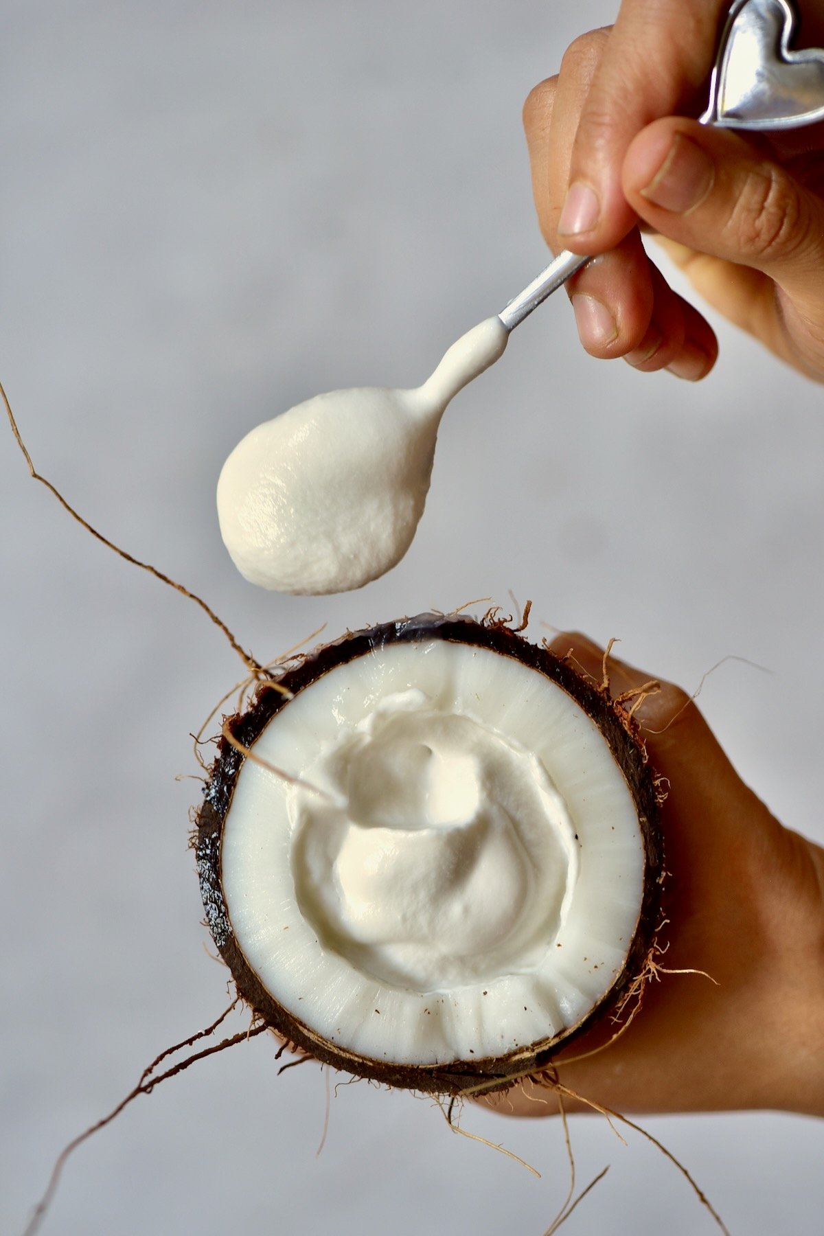 A spoonful of homemade coconut yogurt and half a coconut
