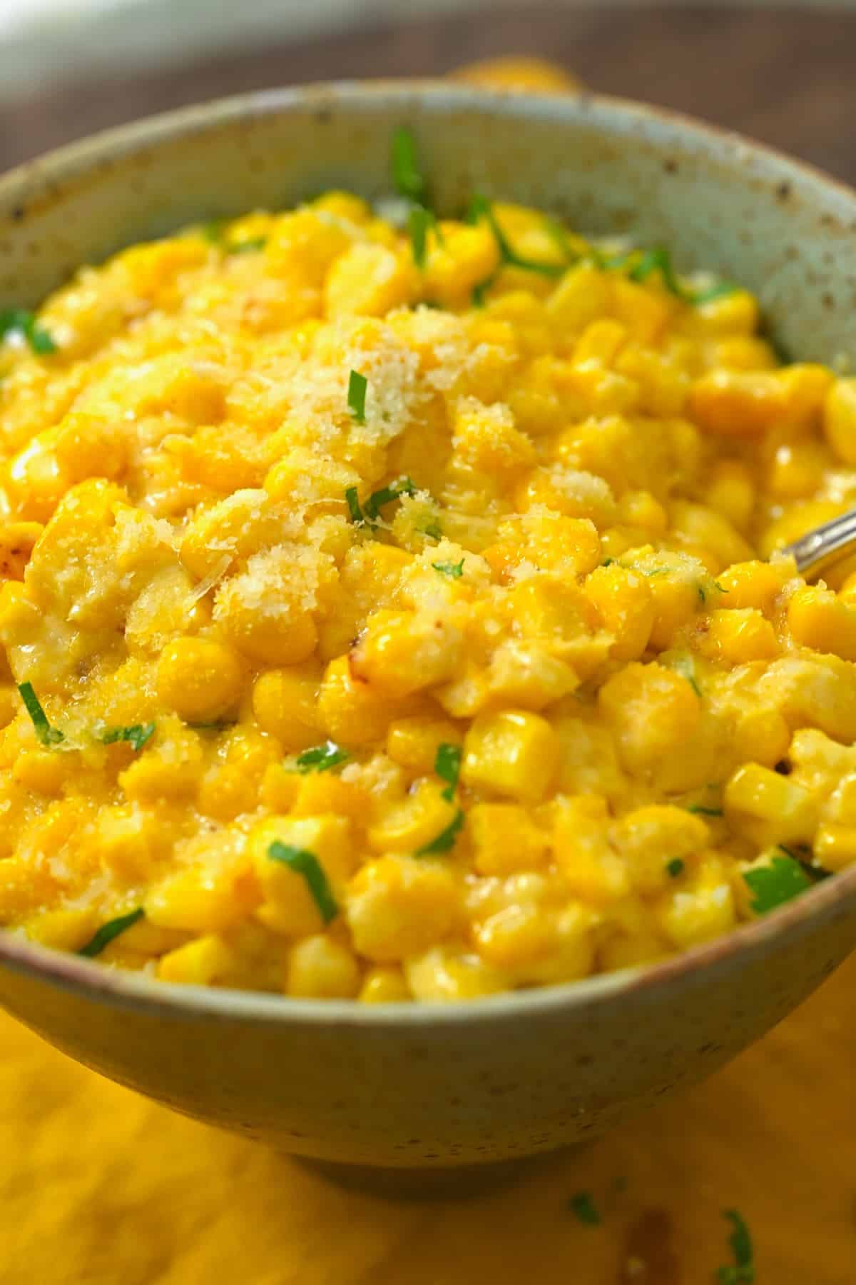 Creamed corn topped with some parmesan