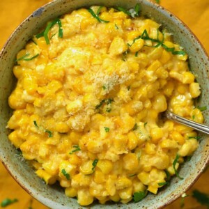A bowl with creamed corn topped with parmesan