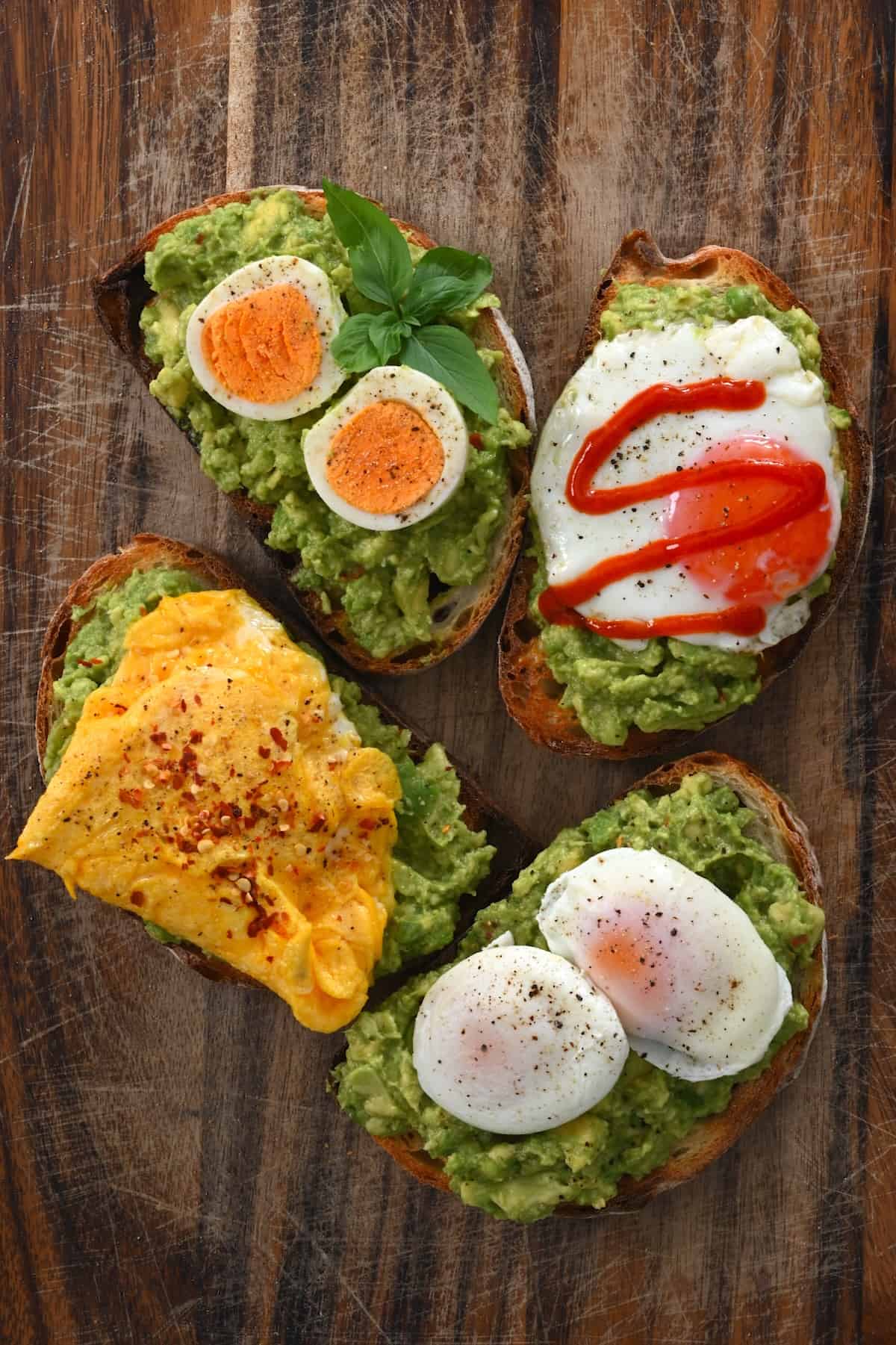 Four avocado toasts with eggs cooked in different ways