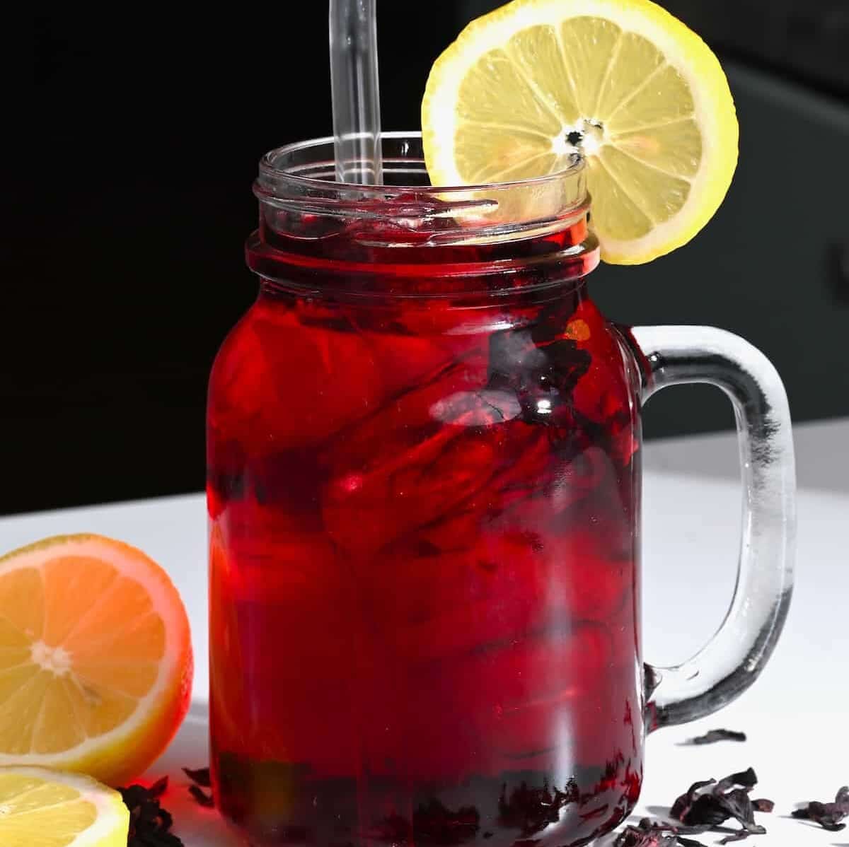 A mason jar with red tea and a lemon slice