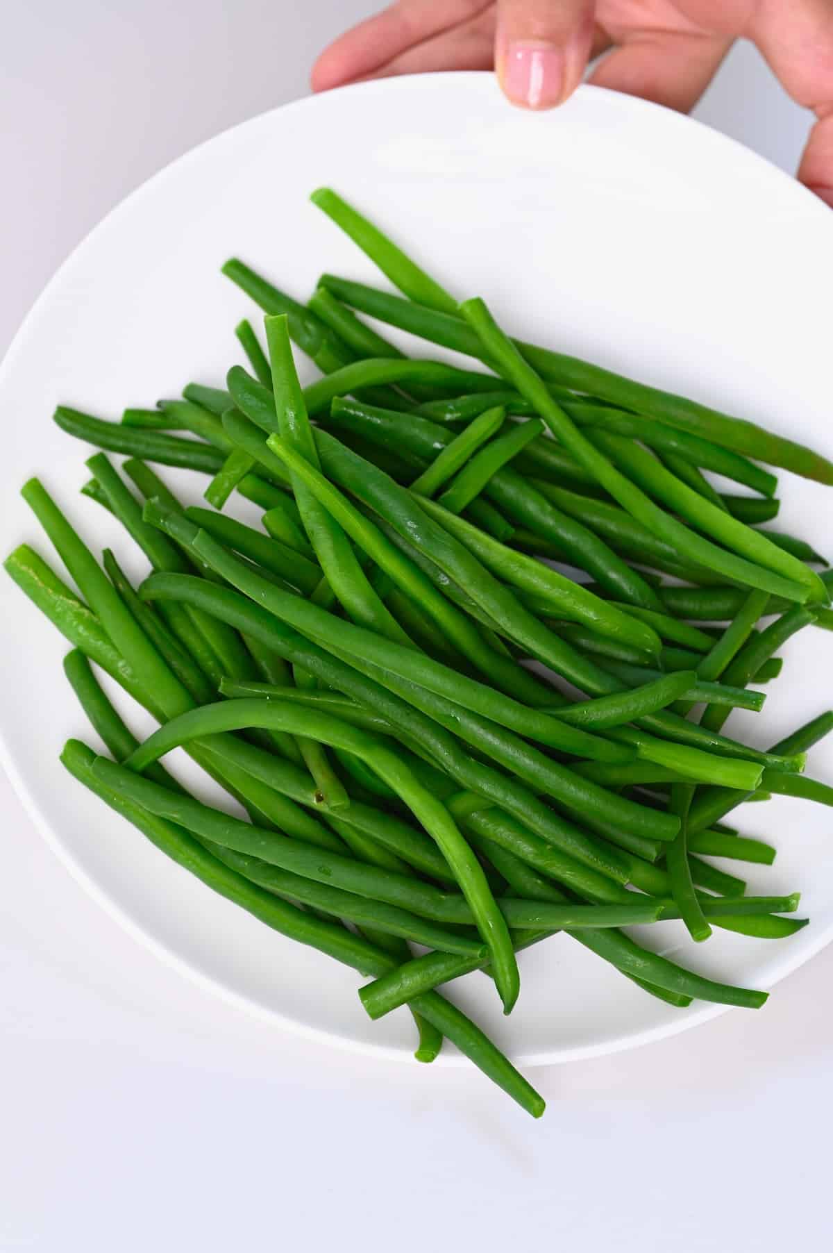 Freshly boiled green beans on a white plate