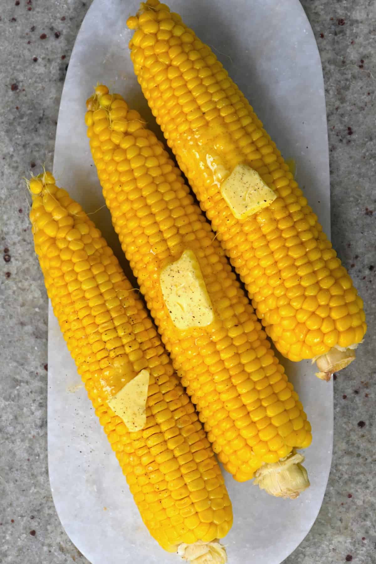 Cooked corn on the cob with melting butter on top