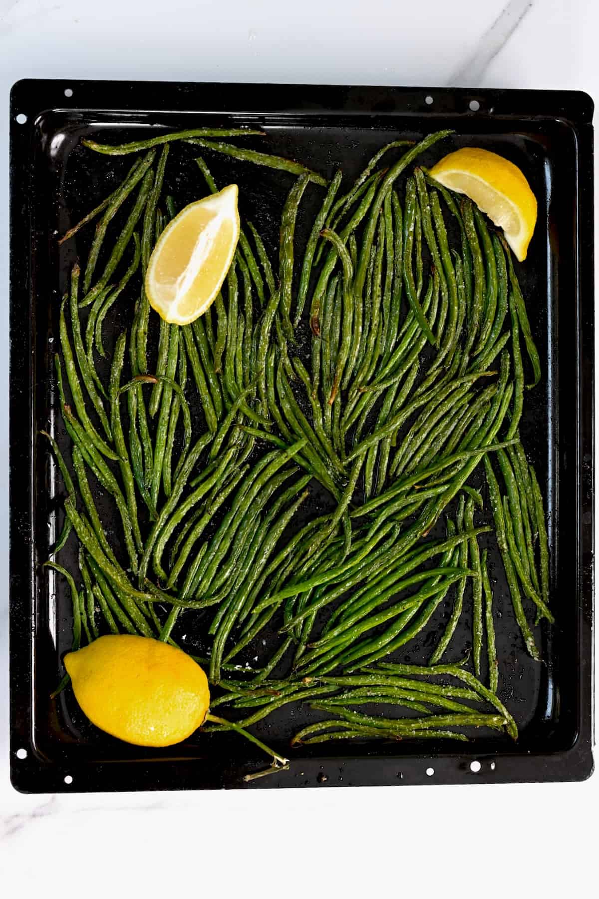Roasted green beans in a baking tray fresh out of the oven