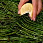 Lemon juice being drizzled over roasted green beans - 14