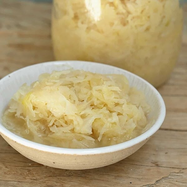 A bowl and a jar with homemade sauerkraut