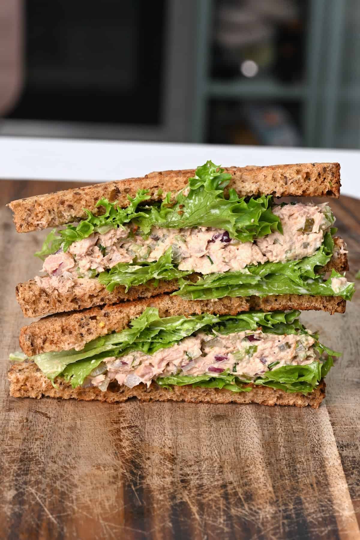 Two halves of tuna salad sandwich on top of each other