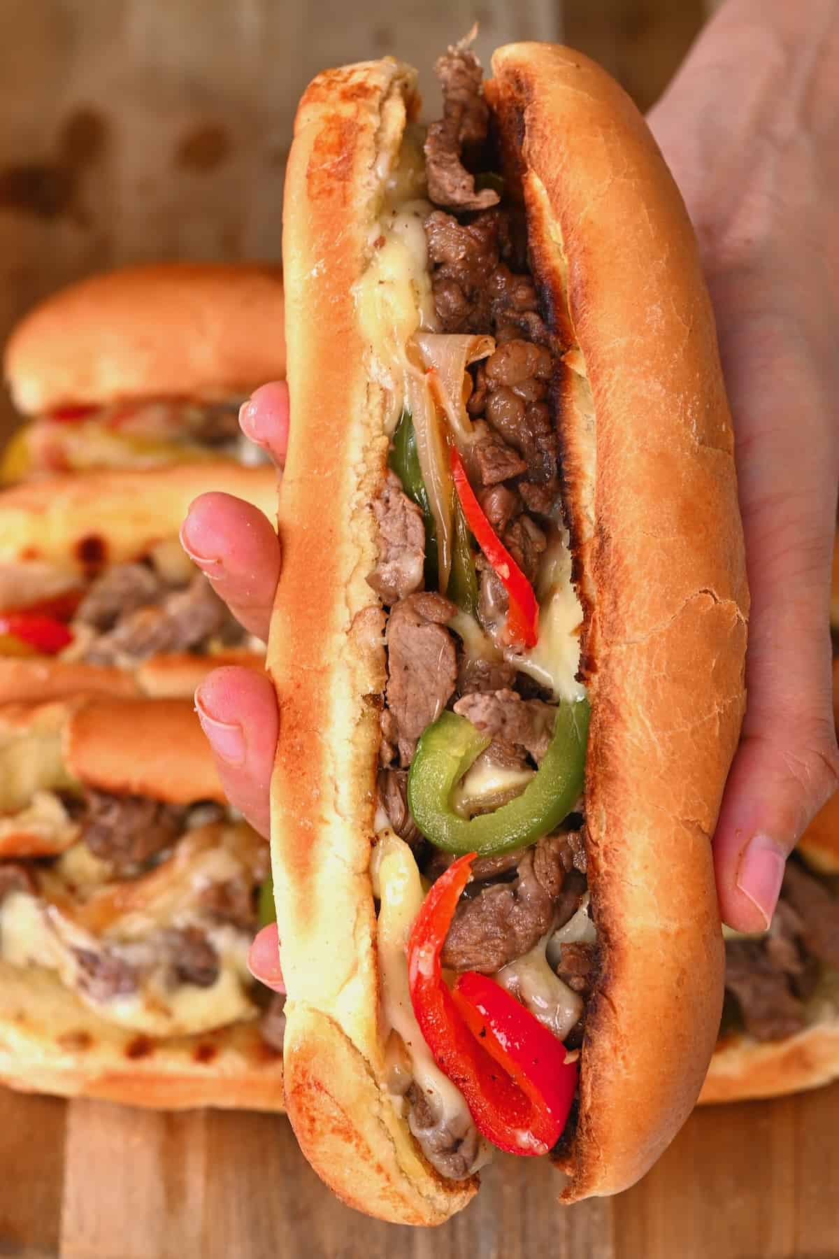 Holding a philly cheesesteak sandwich