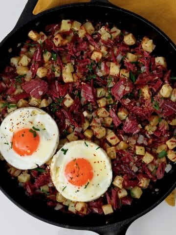 A pan with corned beef hash and two fried eggs