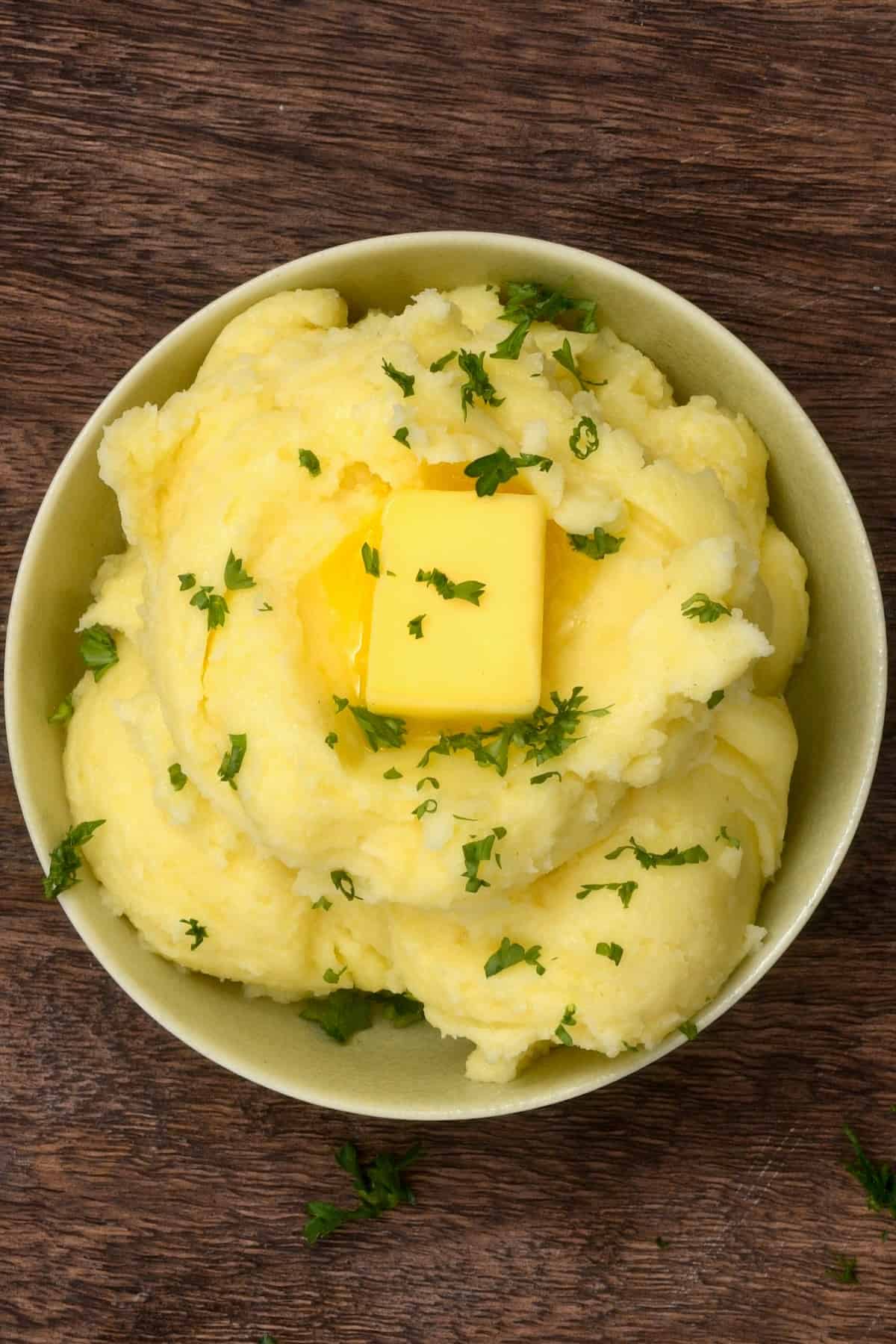 Creamy mashed potatoes topped with butter and parsley