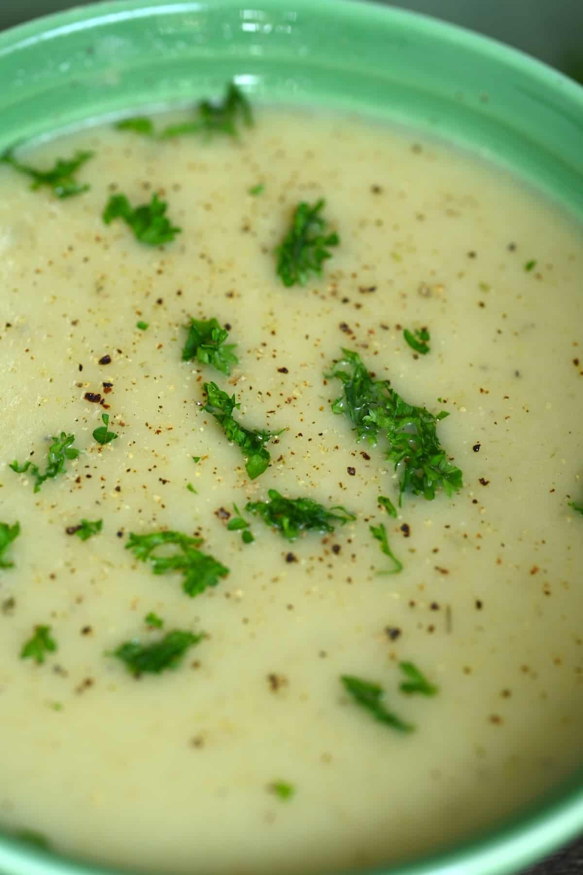 Close up of leek and potato soup topped with herbs