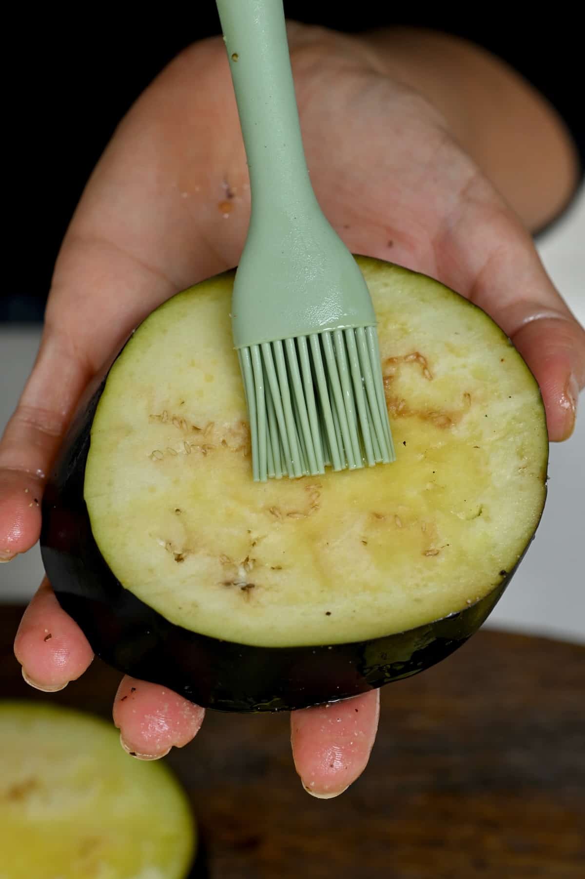 Brushing olive oil on an eggplant slice