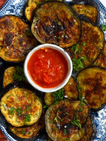 Roasted eggplant slices and tomato sauce on a plate