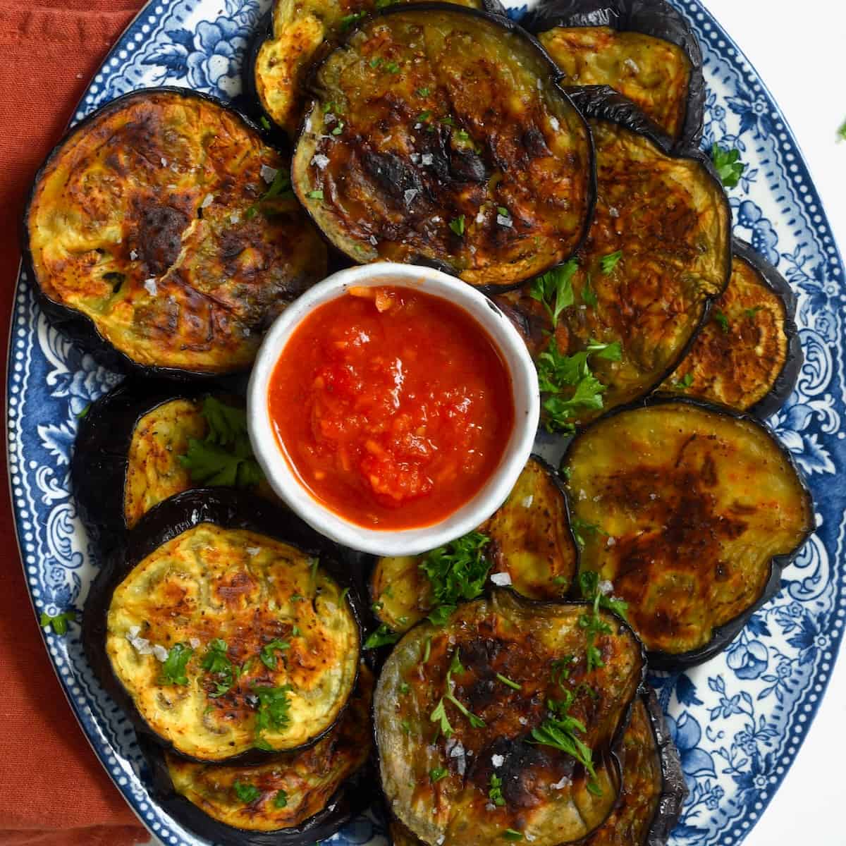 Roasted eggplant slices and tomato sauce on a plate