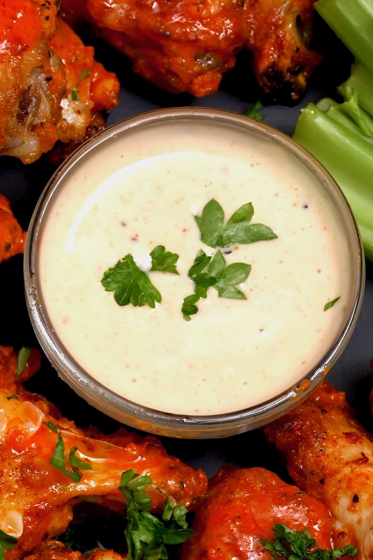 Alabama white sauce in a small bowl with chicken wings