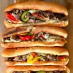 Four Philly cheesesteak sandwiches with melted cheese and peppers - 19