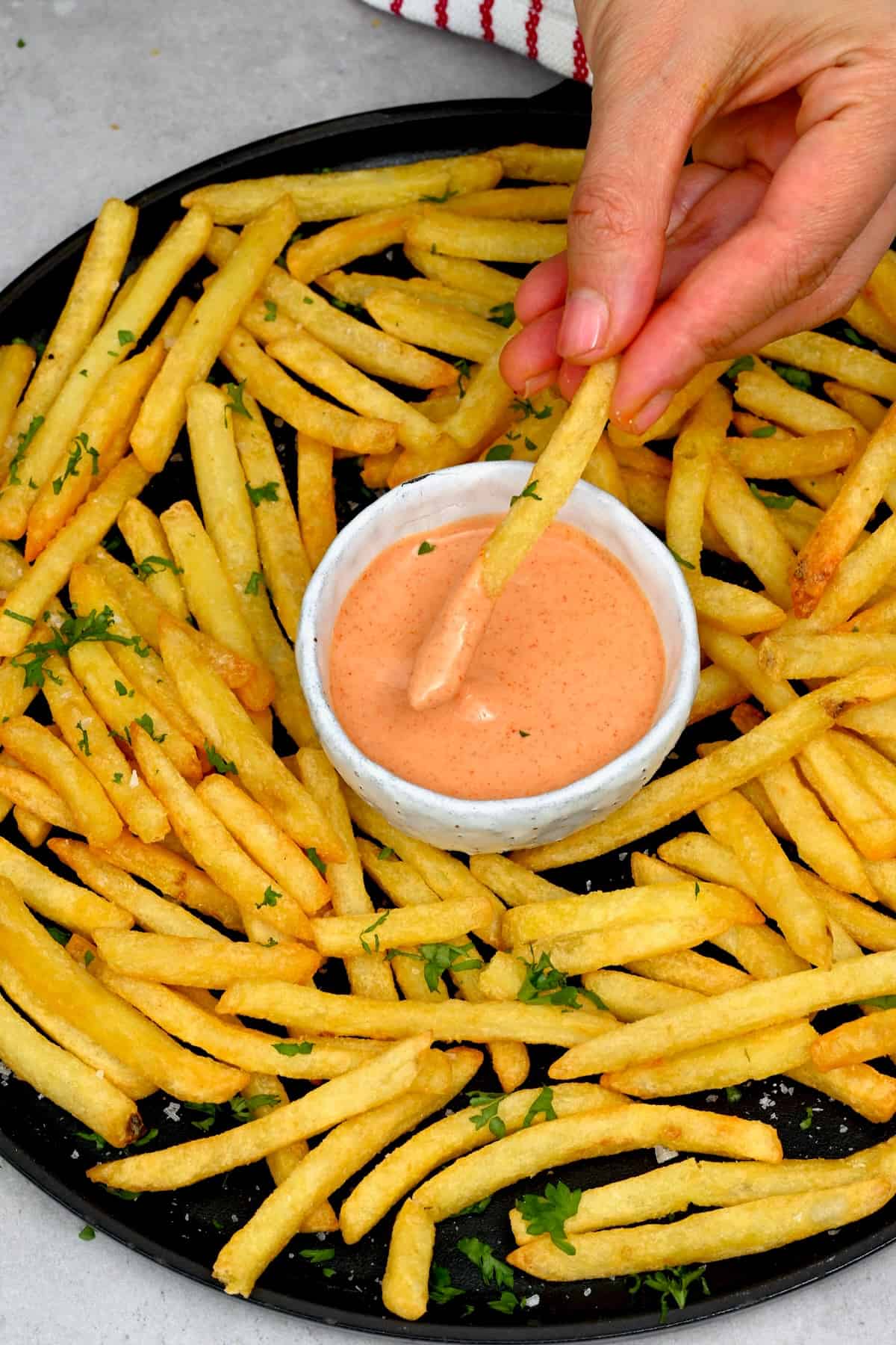 Dipping air fried french fry in dipping sauce