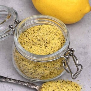A small jar and a spoonful of homemade lemon pepper seasoning