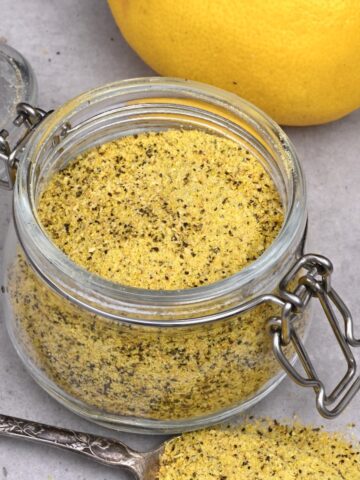 A small jar and a spoonful of homemade lemon pepper seasoning