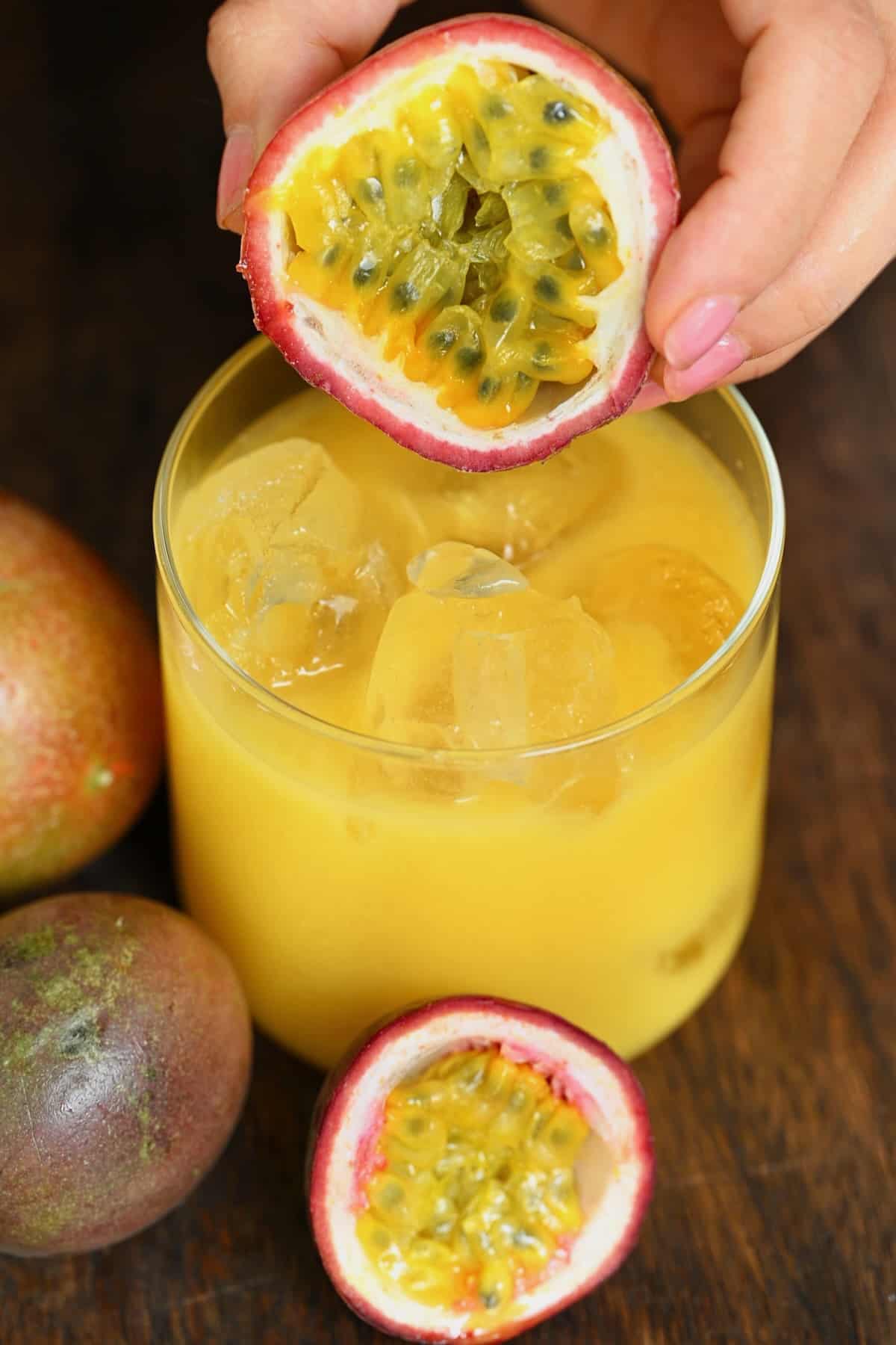 Half a passion fruit and a glass with passion fruit juice
