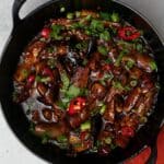 Chinese eggplant stir fry topped with red chili and cilantro