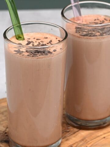Two glasses with chocolate milk and glass straws