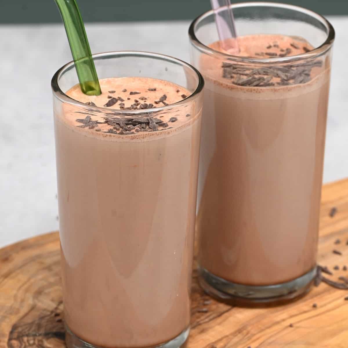 Two glasses with chocolate milk and glass straws