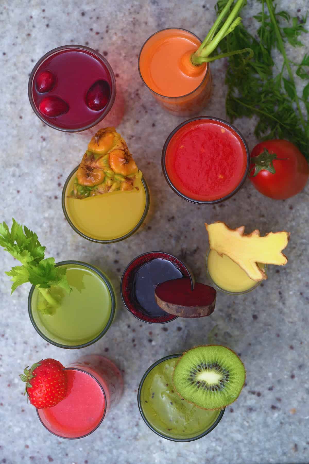 Nine glasses with homemade fresh fruit and veggie juices