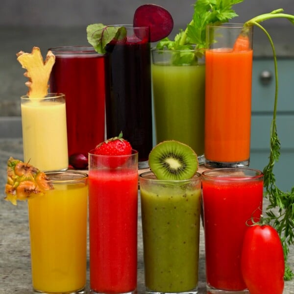 Nine glasses with homemade fresh fruit and veggie juices