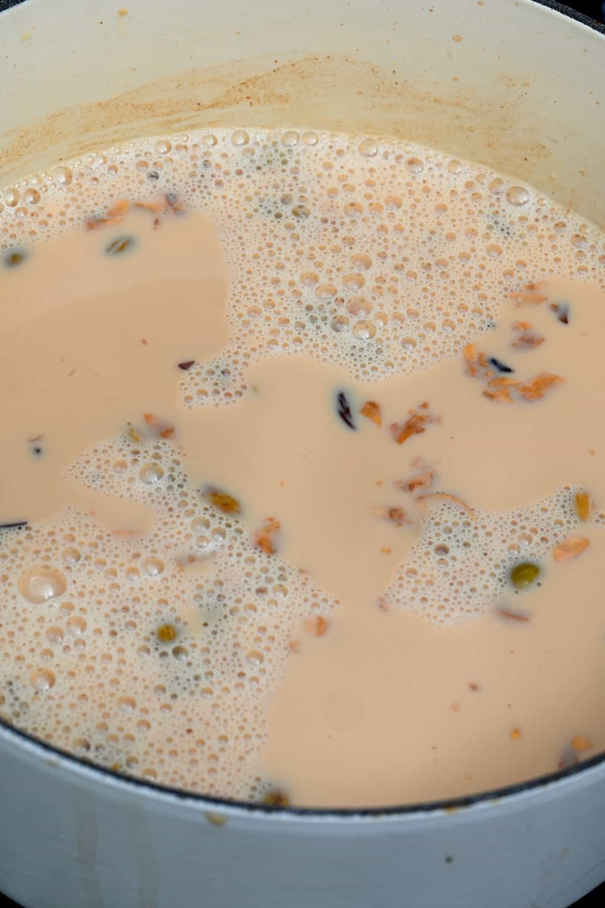 Milk added to black tea mixture with spices