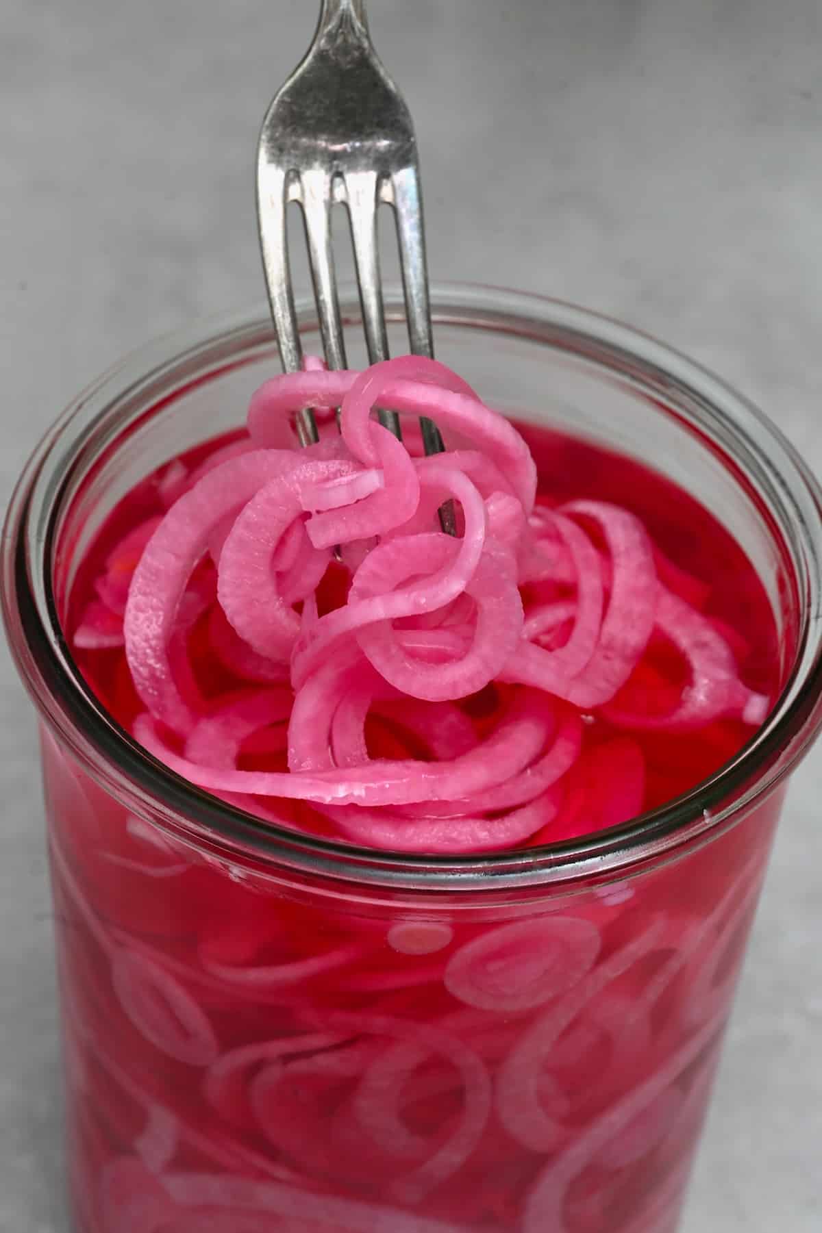 A forkful of pickled red onions
