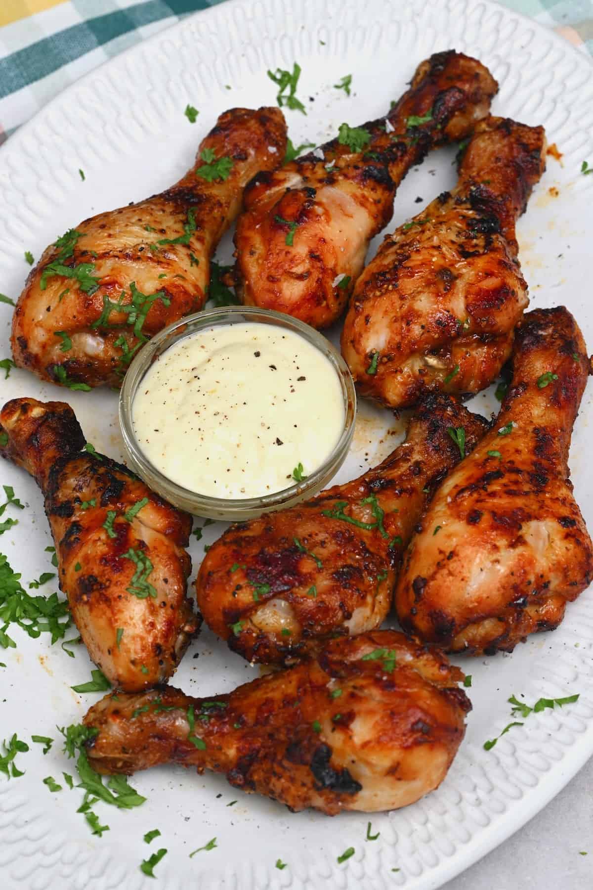 Chicken drumsticks with white sauce in a small bowl