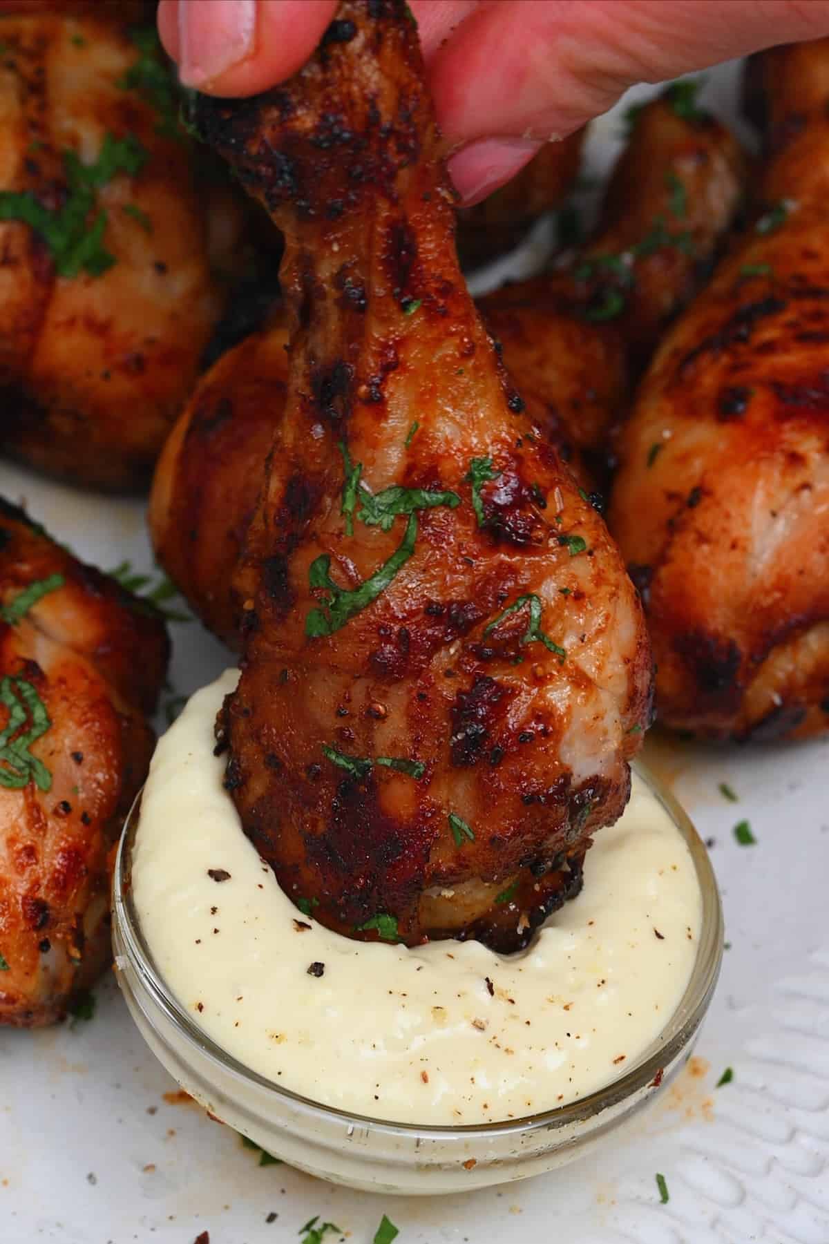 Dipping chicken drumstick in white sauce