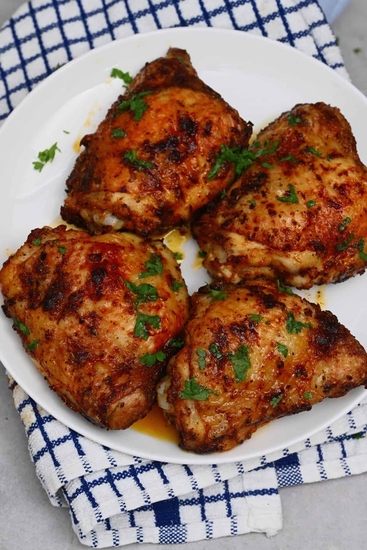 Four air fried chicken thighs topped with parsley